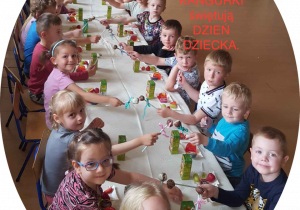 Cała grupa świętuje Dzień Dziecka przy stole ze słodkościami, napojami i owocamii